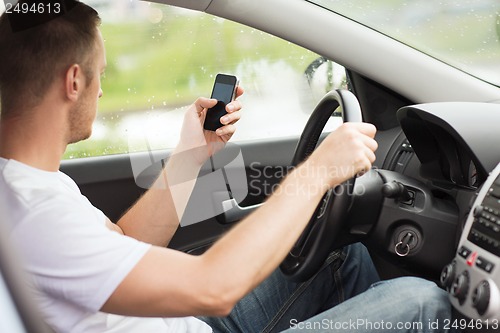 Image of man using phone while driving the car