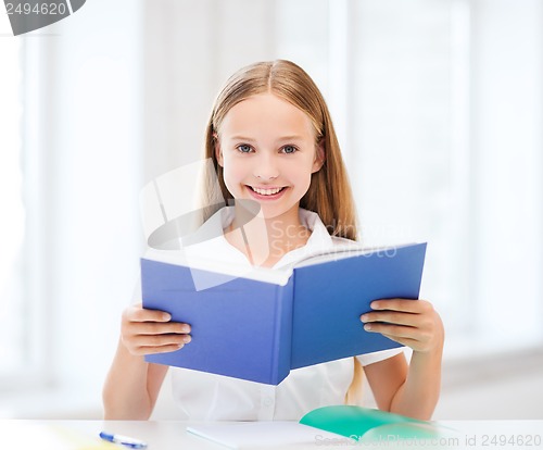 Image of girl studying and reading book at school