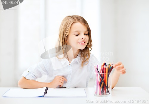 Image of girl drawing with pencils at school