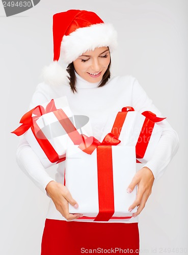 Image of woman in santa helper hat with many gift boxes