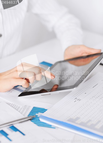 Image of woman with tablet pc and chart papers