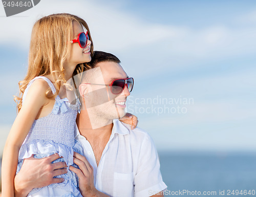 Image of happy father and child in sunglasses over blue sky