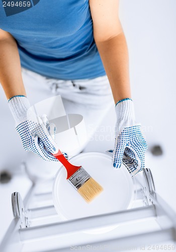 Image of woman with paintbrush and paint pot