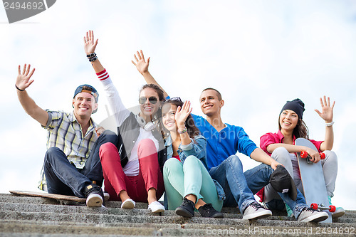 Image of group of teenagers waving hands