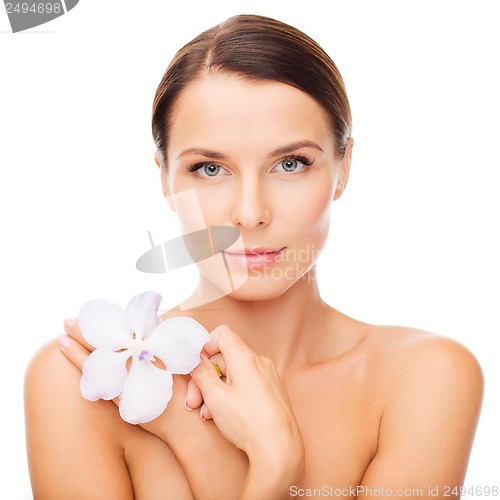 Image of relaxed woman with orhid flower