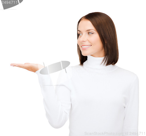 Image of woman in white sweater with something on palm