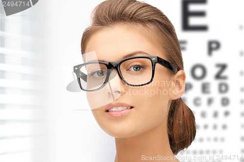 Image of woman in eyeglasses with eye chart