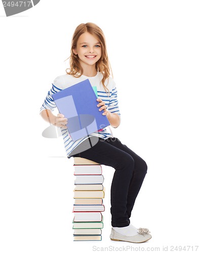 Image of little student girl sitting on stack of books