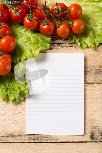 Image of vegetables and blank paper on wood background