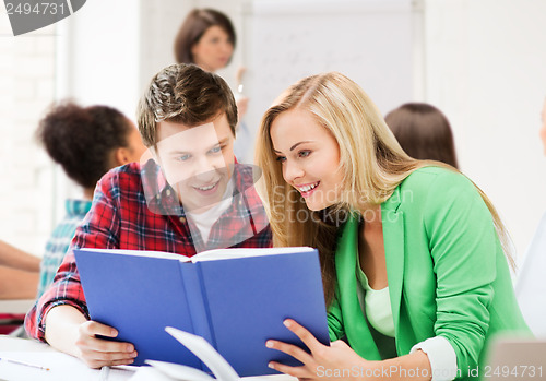Image of students reading book at school