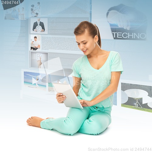 Image of young girl sitting on the floor with tablet pc