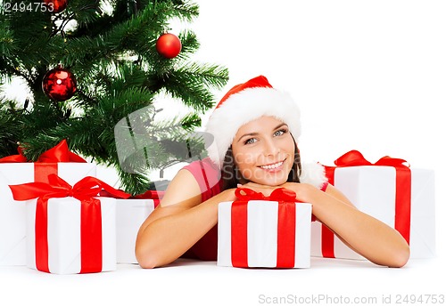 Image of smiling woman in santa helper hat with gift boxes