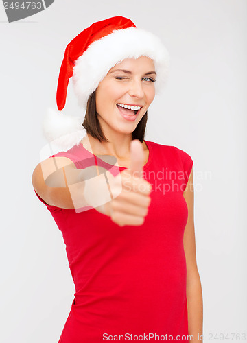 Image of woman in santa helper hat showing thumbs up