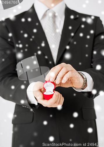 Image of man with gift box and wedding ring