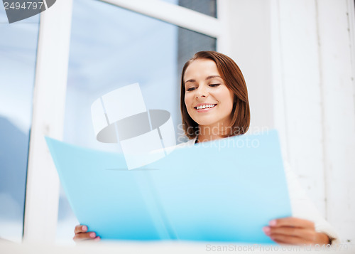 Image of businesswoman with folder in office