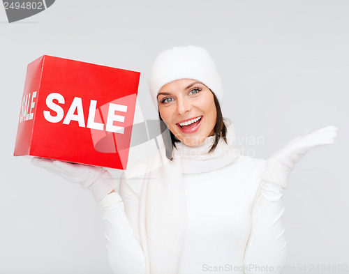 Image of woman in winter clothes with red sale sign