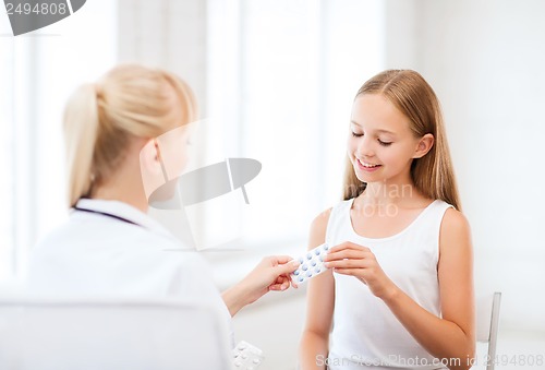 Image of doctor giving tablets to child in hospital