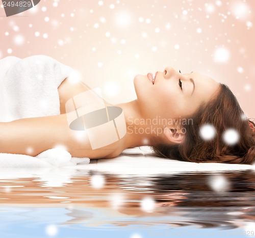 Image of woman in spa salon lying on the massage desk