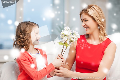 Image of happy mother and daughter with flowers