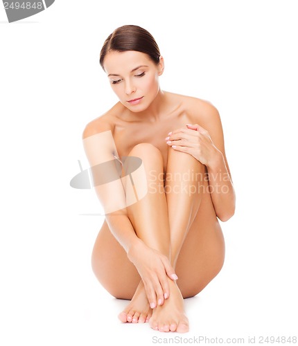 Image of beautiful naked woman touching her legs