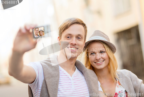 Image of travelling couple taking photo picture with camera