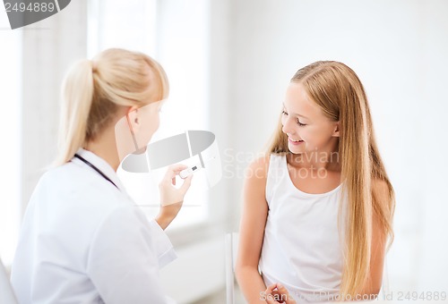 Image of doctor with child measuring temperature