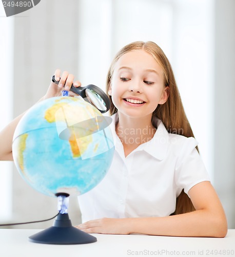 Image of child looking at globe with magnifier