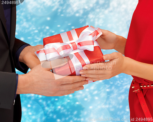 Image of man and woman hands with gift box
