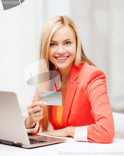 Image of businesswoman with laptop using credit card