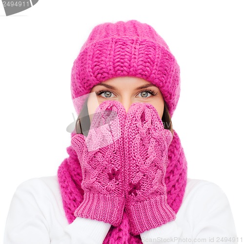 Image of surprised woman in hat, muffler and mittens