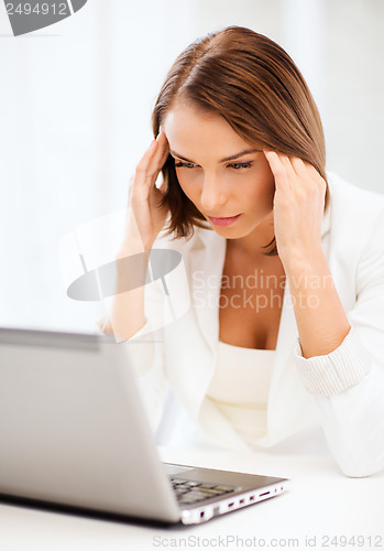 Image of businesswoman with laptop in office