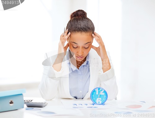 Image of businesswoman working with calculator in office