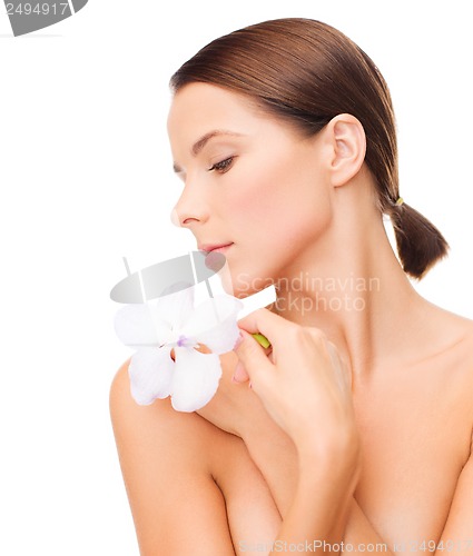 Image of relaxed woman with or??hid flower