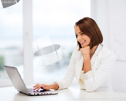 Image of businesswoman with laptop in office