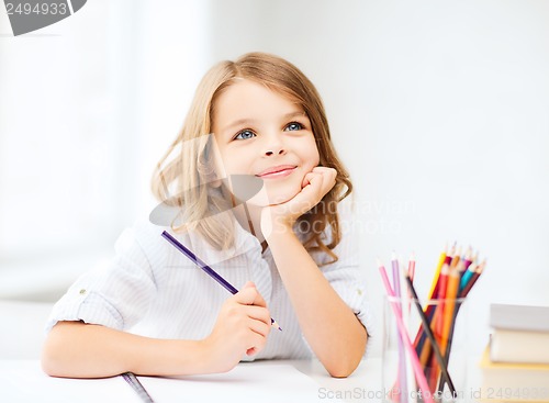 Image of girl drawing with pencils at school