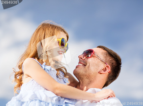 Image of happy father and child in sunglasses over blue sky