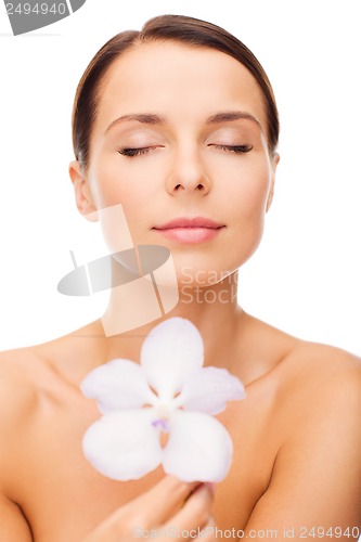 Image of relaxed woman with orhid flower