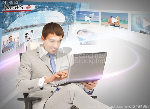 Image of businessman with laptop pc reading news