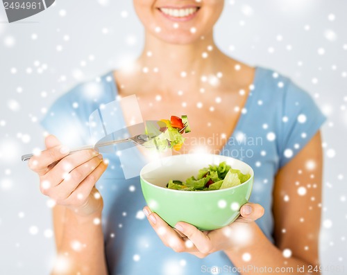 Image of woman eating salad with vegetables