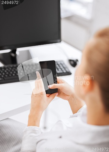 Image of businesswoman with smartphone in office