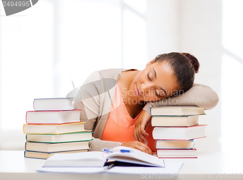 Image of tired student with books and notes