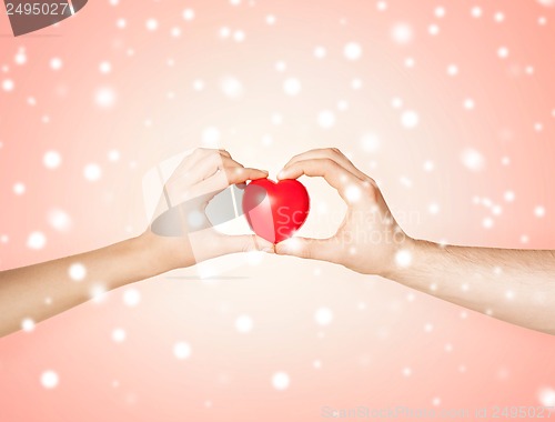 Image of woman and man hands with heart