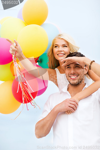 Image of couple with colorful balloons at seaside