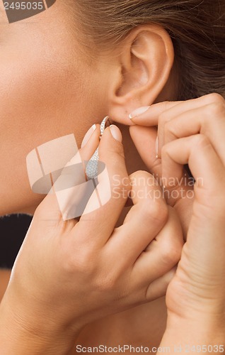 Image of woman wearing shiny diamond earrings