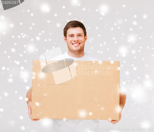 Image of smiling man carrying carton box
