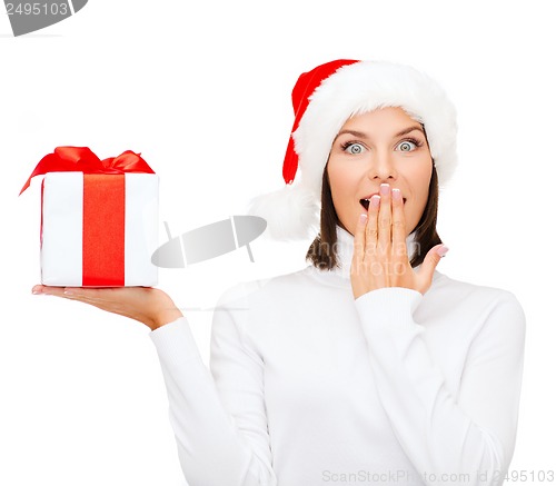 Image of surprised woman in santa helper hat with gift box