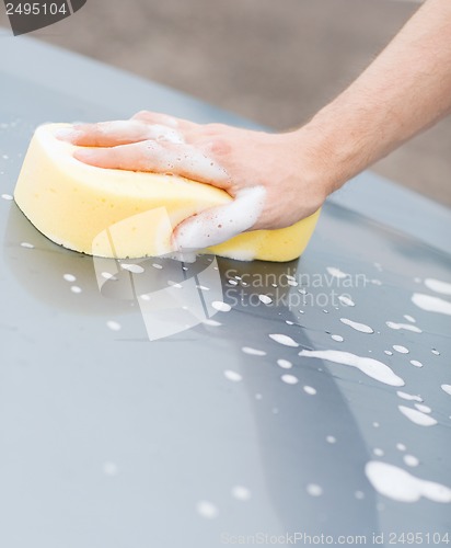 Image of man washing a car