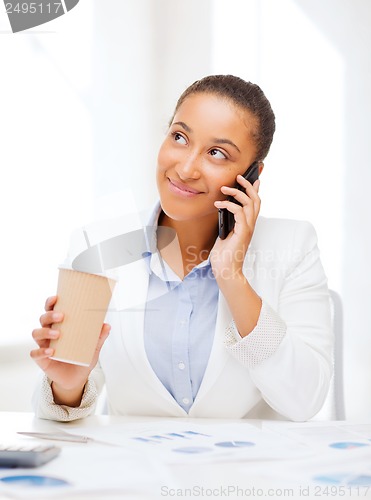 Image of african businesswoman with smartphone in office