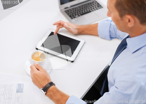 Image of businessman with tablet pc and coffee in office