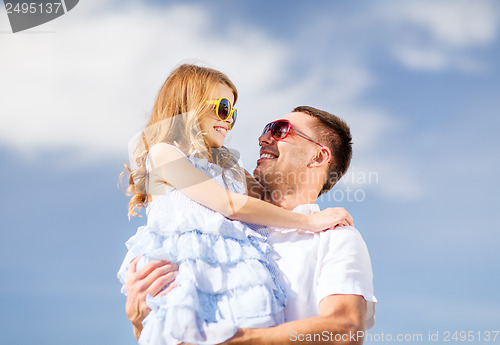 Image of happy father and child in sunglasses over blue sky